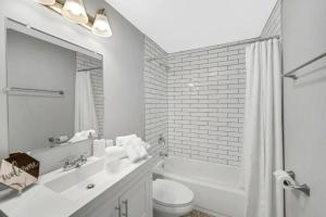 a white bathroom with a sink and a toilet at Spacious Haven 8-Min to Chicago Sleeps 10 in Forest Park
