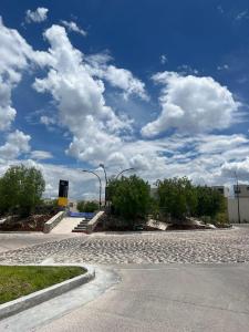 an empty street with a blue sky and clouds at Acogedora casa in Querétaro