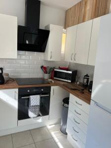 a kitchen with white cabinets and a microwave at Sixty Four in The Mumbles