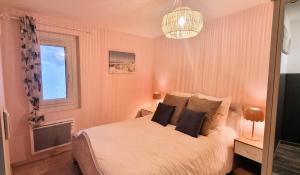 - une chambre avec un lit blanc, une fenêtre et un lustre dans l'établissement Authentique Maison Sétoise 2 chambres Patio Proximité Parking Climatisation, à Sète