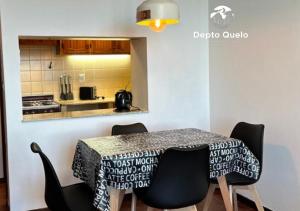 a dining room with a table and chairs and a kitchen at Depto. Quelo in San Carlos de Bariloche