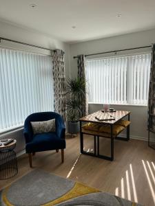 a living room with a blue chair and a table at Sixty Four in The Mumbles