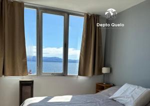 a bedroom with a window with a view of the water at Depto. Quelo in San Carlos de Bariloche
