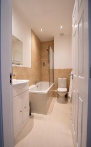 a bathroom with a tub and a toilet and a sink at Sunny View in Scarborough +9 photos