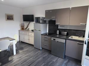 a kitchen with stainless steel appliances and a table at Gîte La vue étoilée in Curbans