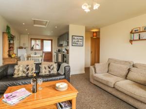 a living room with a couch and a table at Brindle Cottage in Lydiard Millicent