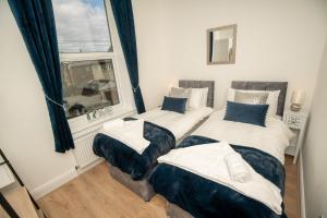 two twin beds in a room with a window at Sunny View in Scarborough