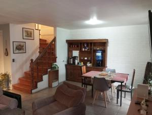 a living room with a table and a kitchen at Hostal Rucatremo in Curicó