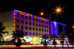 a building with purple lights on the side of it at Qaser Al-Sultan Hotel Suites in Amman