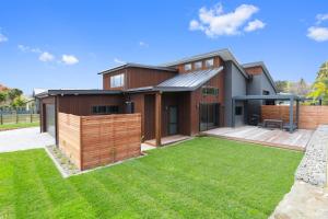 a house with a fence and a yard at Serenity on Sophia in Rotorua