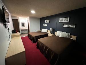 ein Hotelzimmer mit 2 Betten und einem Flachbild-TV in der Unterkunft country club inn in Colby