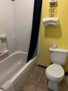 ein Badezimmer mit einem weißen WC und einer Badewanne in der Unterkunft country club inn in Colby