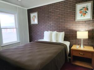 ein Hotelzimmer mit einem Bett und einer Ziegelwand in der Unterkunft country club inn in Colby