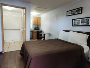 ein Hotelzimmer mit einem Bett und einer Küche in der Unterkunft country club inn in Colby