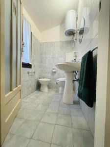 Baño blanco con lavabo y aseo en Casa del Viandante Borgo dei Sassi di Roccamalatina en Guiglia