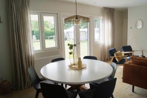 a living room with a white table and chairs at Chalet 't Zwaluwnest in Aagtekerke