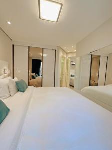 um grande quarto branco com uma grande cama branca em Moema Times Square SP - Luxury Suíte em São Paulo