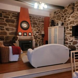 a living room with a white chair in front of a fireplace at El Abuelo Angel in Ribadavia