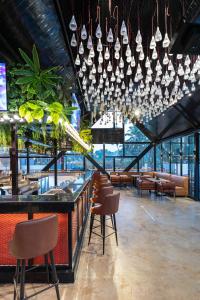 un restaurante con un bar con sillas y lámparas de araña en The Upper House resort by J R high Sky, en Morjim