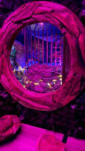 een kamer met een stenen muur en paarse verlichting bij La Terrasse Des Spas in Hazebrouck