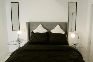 una camera da letto con un letto con due tavoli e due specchi di Vibrant & Modern Loft-style Walkout Near LRT a Calgary
