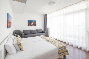 um quarto com uma cama grande e um sofá em Rooftop City Residence em Budapeste