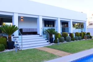 um edifício branco com escadas ao lado de uma piscina em Villa lujo Costa del Sol con piscina-jacuzzi em Torremolinos