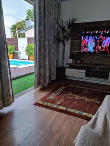 un soggiorno con TV a schermo piatto di fronte a una finestra di Casa com piscina em Torres/RS a Torres