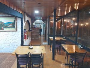 モンテベルデ・コスタリカにあるCabinas Vista Al Golfoの木製のテーブルと椅子、カウンターが備わるレストラン