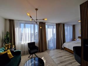 a bedroom with a bed and a couch and a chair at 7thHeaven centre suite FREE PARKING in the building in Bratislava