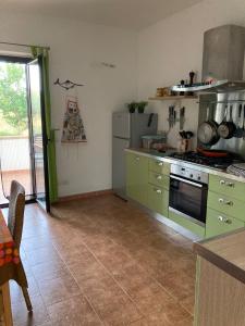 una cucina con armadi verdi e piano cottura di Apartment F24 Stignano Favaco a Focà
