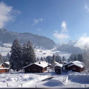 un villaggio ricoperto di neve con case su una montagna di Alpenblick Loft neben Skilift in Amden Arvenbüel ad Amden