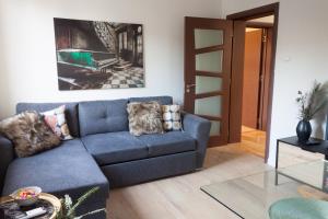 a living room with a blue couch and a piano at Charisma in Haskovo