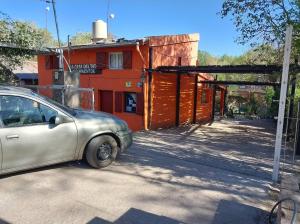 een kleine auto geparkeerd voor een gebouw bij Cabañas la Casa del Tata in Potrero de los Funes