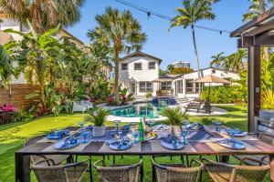 a dining table in front of a house with a pool at Special Pricing, Las Olas Retreat, Heated Pool, Golf and Family-Ready in Fort Lauderdale