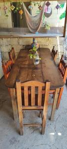 uma mesa e cadeiras de madeira com uma planta em Ivanna hostel mazunte em Mazunte