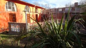 un edificio naranja con una planta delante en Cabañas la Casa del Tata, en Potrero de los Funes