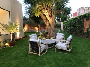 un patio con mesa y sillas en el césped en Casa Tlaxcalli by Beddo Hoteles en Tlaxcala de Xicohténcatl