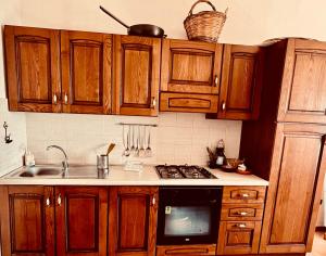 a kitchen with wooden cabinets and a stove top oven at Rifugio Acquaviva in Formia +20 photos