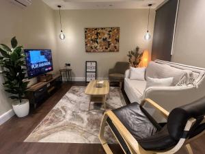 sala de estar con sofá y TV en Cozy apartment, two bedroom, full kitchen, en Riad