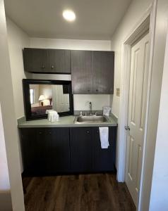 a small kitchen with a sink and a mirror at Desert Sands Inn & Suites in Albuquerque