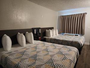 a hotel room with two beds and a window at Studio 6 Sacramento, CA Natomas in Sacramento