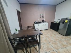 a kitchen with a table and chairs and a refrigerator at Cabinas Guayabón #5, AC, La Fortuna San Carlos in Fortuna +15 photos