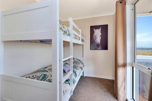 a bedroom with bunk beds and a window at High View Family Cottages in Warrnambool