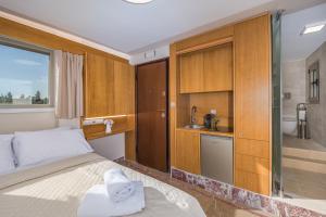 a bedroom with a bed and a sink and a bathroom at Acropolis and Odeon Panorama in Athens