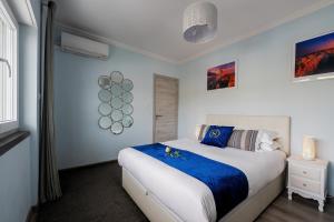 a bedroom with a large bed with blue and white sheets at Gold Coast Photography Inn in Estoril