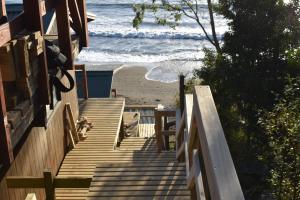 una escalera de madera que conduce a una playa con el océano en MARE VENTUM en Valdivia