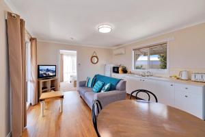 a kitchen and a living room with a table and a couch at High View Family Cottages in Warrnambool