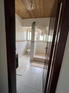 a bathroom with a shower and a toilet in a room at Emron Homelodge in Accra