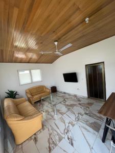 a living room with a couch and a tv at Emron Homelodge in Accra